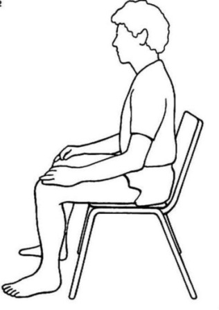 Meditating sitting in a chair. Feet flat on the floor. Hands resting on thighs. Back straight.